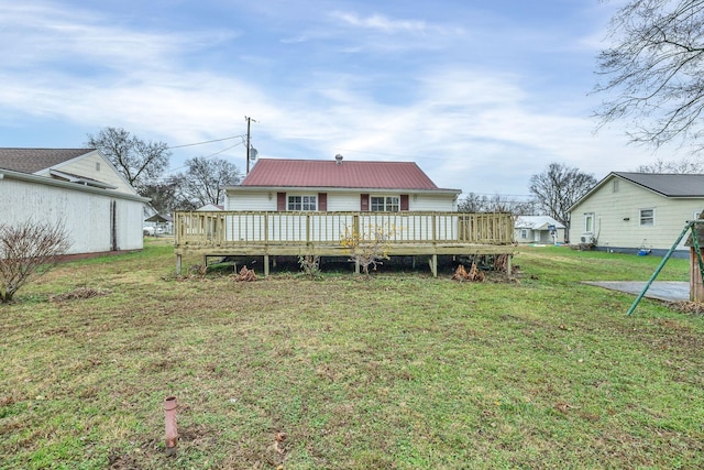 back of house featuring a deck and a lawn