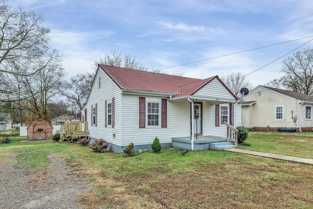 view of front of property featuring a storage unit and a front yard