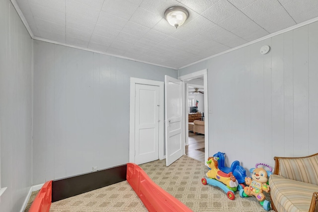 bedroom featuring crown molding and wooden walls