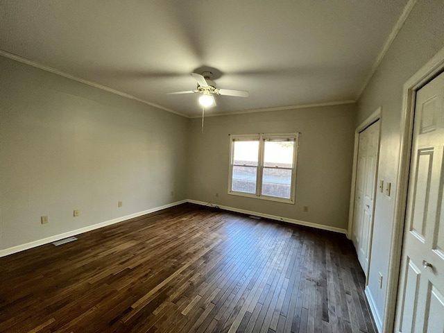 unfurnished bedroom featuring ornamental molding, dark wood-type flooring, and ceiling fan