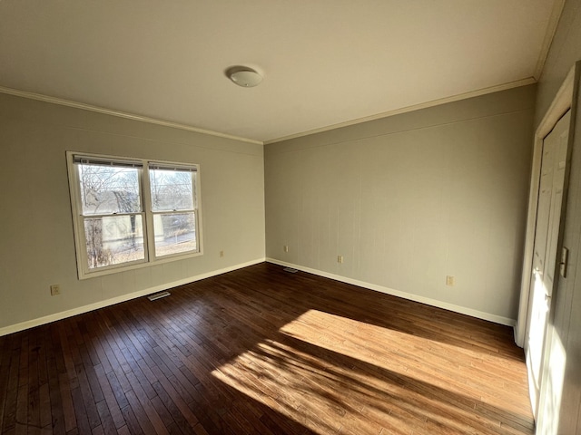 spare room featuring wood-type flooring and crown molding