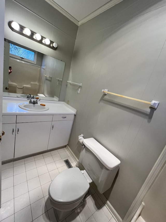 bathroom with tile patterned flooring, vanity, crown molding, and toilet