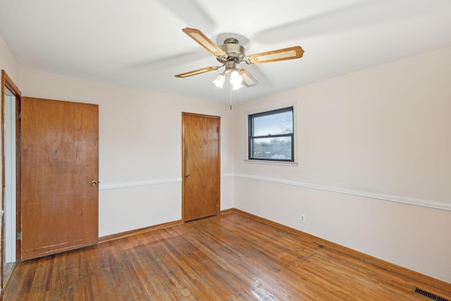 unfurnished bedroom with ceiling fan and dark hardwood / wood-style flooring