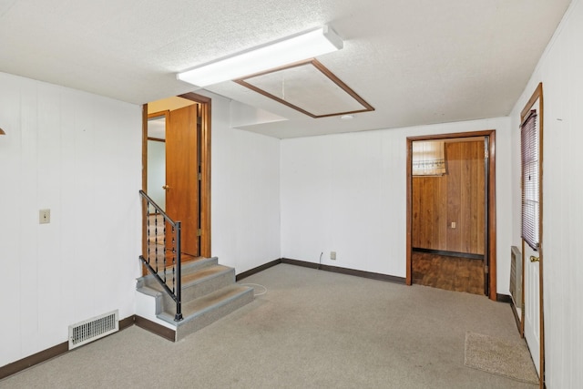 basement featuring a textured ceiling and carpet flooring