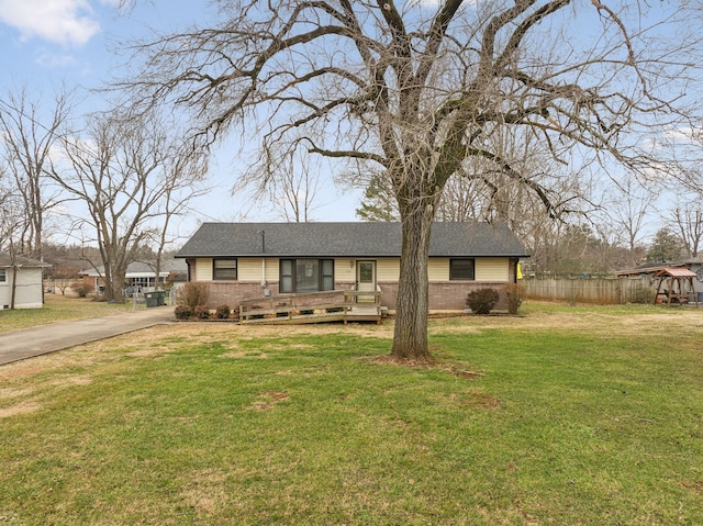 ranch-style house featuring a wooden deck and a front lawn