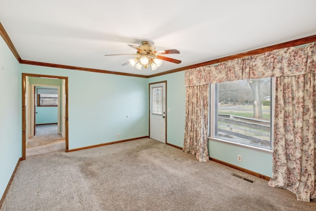 empty room with light carpet, crown molding, and ceiling fan