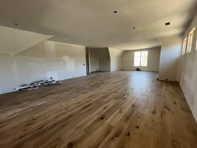 additional living space featuring vaulted ceiling and hardwood / wood-style floors