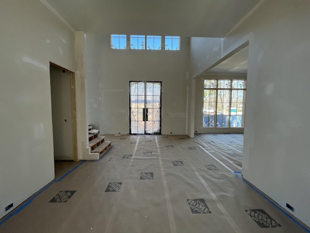 unfurnished living room with a towering ceiling