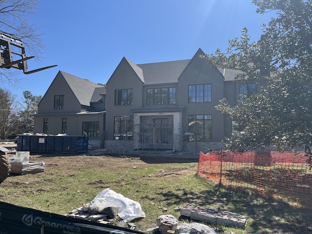 rear view of house featuring stucco siding