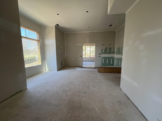 unfurnished room featuring plenty of natural light and crown molding