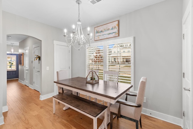 dining room with an inviting chandelier and light hardwood / wood-style floors