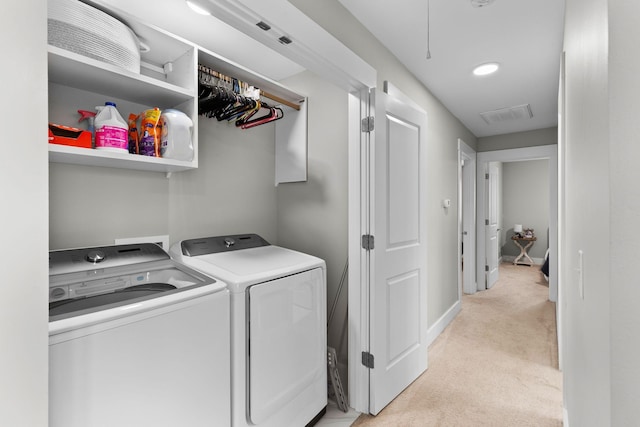 laundry room with separate washer and dryer and light carpet