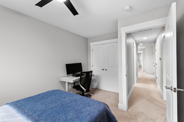 bedroom with light colored carpet, ceiling fan, and a closet