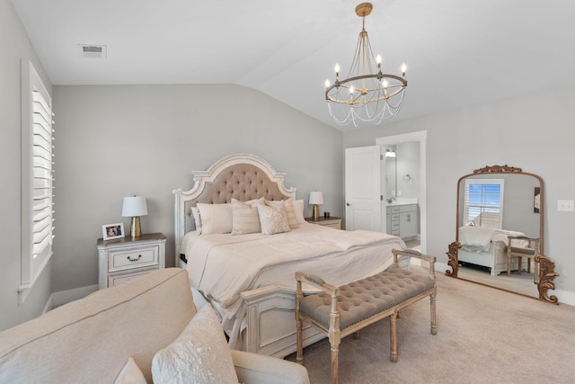 carpeted bedroom with ensuite bathroom and vaulted ceiling