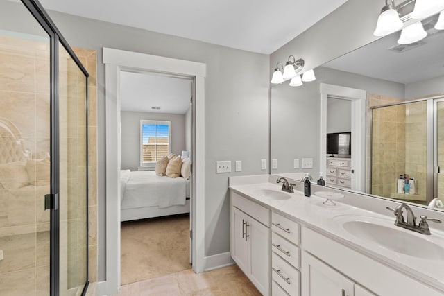 bathroom with a shower with door, vanity, and tile patterned floors