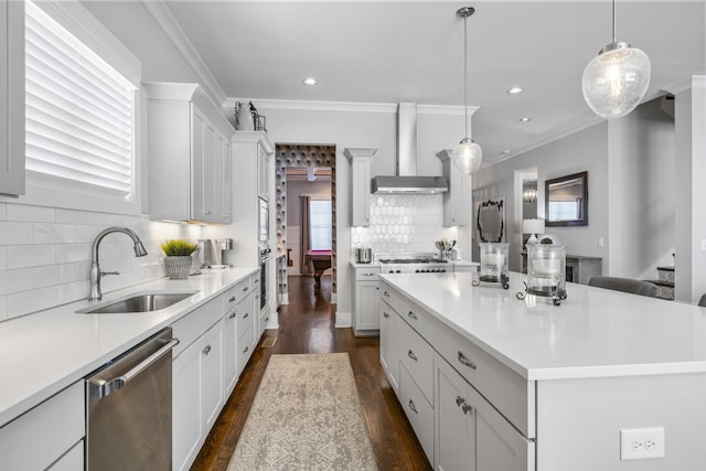 kitchen with a kitchen island, appliances with stainless steel finishes, sink, white cabinets, and hanging light fixtures