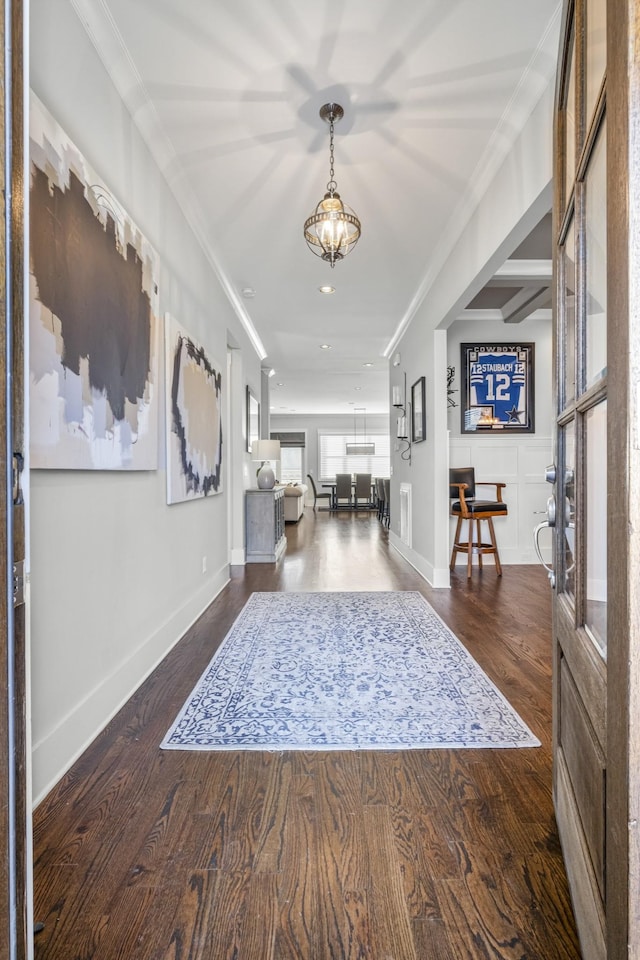 entrance foyer with crown molding and dark wood-type flooring