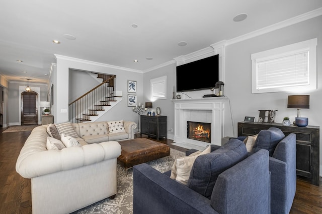 living room with ornamental molding, dark hardwood / wood-style floors, and a tile fireplace