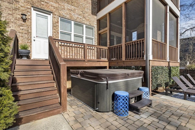 view of patio / terrace with a hot tub and a sunroom