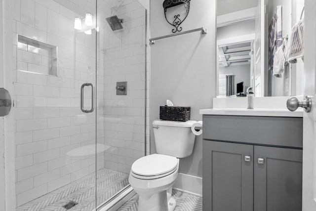 bathroom featuring vanity, an enclosed shower, and toilet