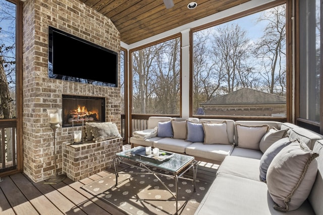 sunroom / solarium featuring wood ceiling, lofted ceiling, and a brick fireplace