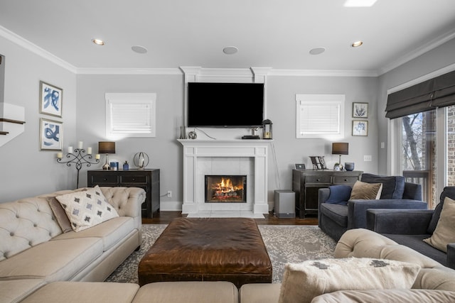 living room featuring a tile fireplace, crown molding, and hardwood / wood-style floors