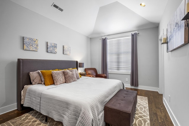 bedroom with vaulted ceiling and dark hardwood / wood-style floors