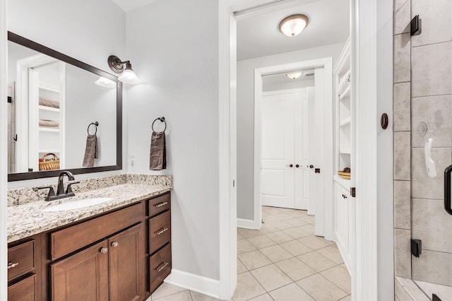 bathroom featuring tile patterned flooring, vanity, and walk in shower