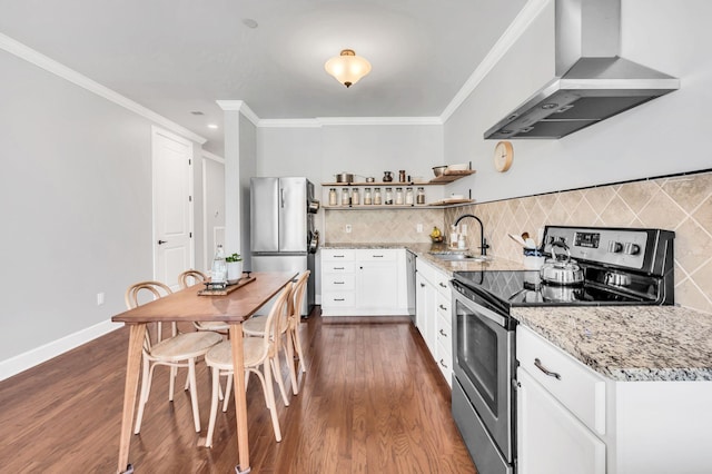 kitchen with appliances with stainless steel finishes, white cabinetry, sink, light stone countertops, and wall chimney range hood