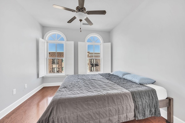 bedroom with dark wood-type flooring, ceiling fan, and vaulted ceiling