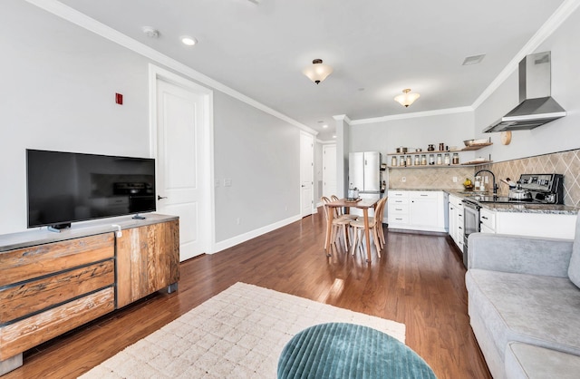 living room featuring dark wood-type flooring, crown molding, and sink