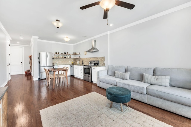 living room with crown molding, ceiling fan, and dark wood-type flooring