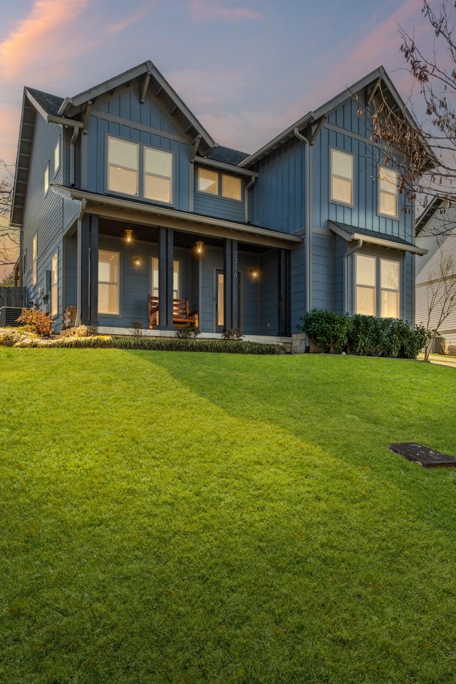 view of front of house with covered porch and a lawn