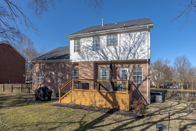 back of property with cooling unit, a yard, and a deck