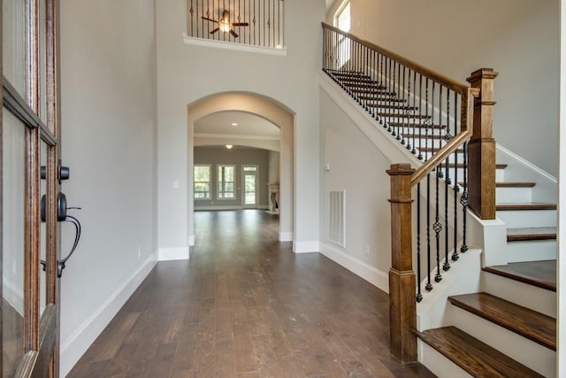 foyer entrance with dark hardwood / wood-style flooring and a high ceiling