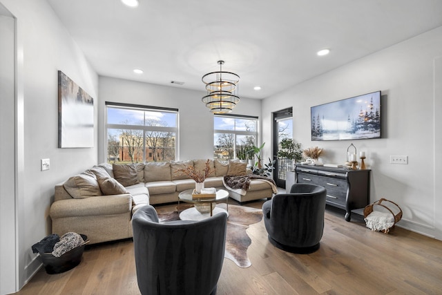 living room featuring an inviting chandelier and hardwood / wood-style floors