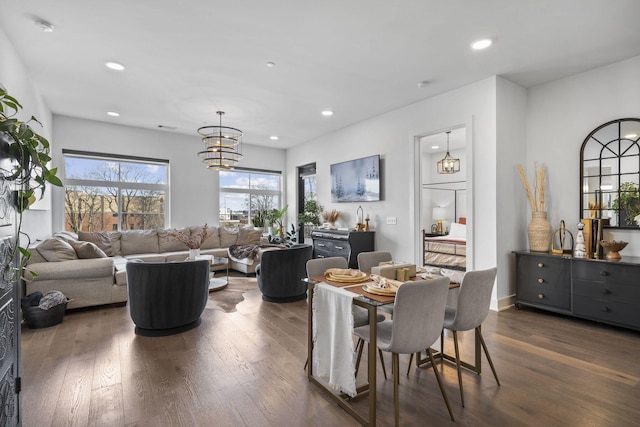 dining area with dark wood-type flooring and a notable chandelier