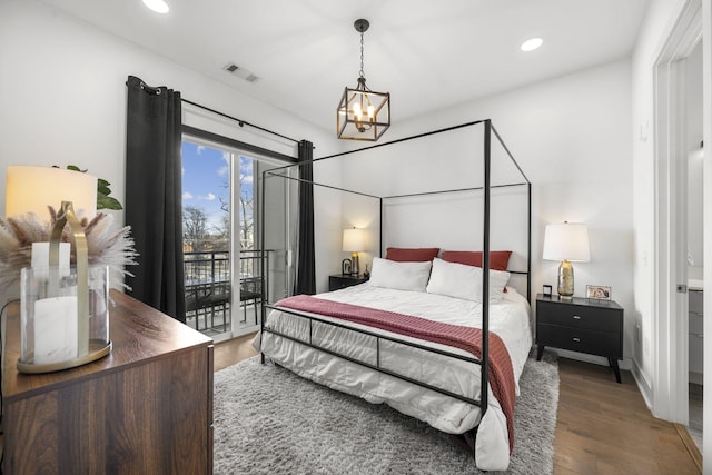 bedroom featuring an inviting chandelier, dark wood-type flooring, and access to outside