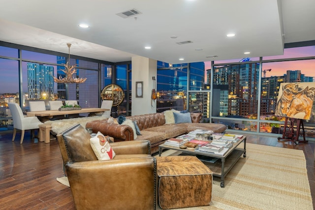 living room with an inviting chandelier, floor to ceiling windows, and hardwood / wood-style floors