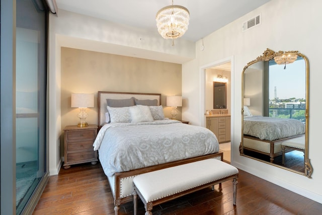 bedroom with ensuite bathroom, dark wood-type flooring, and a chandelier