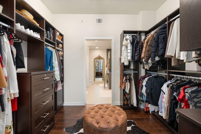 walk in closet with dark hardwood / wood-style flooring