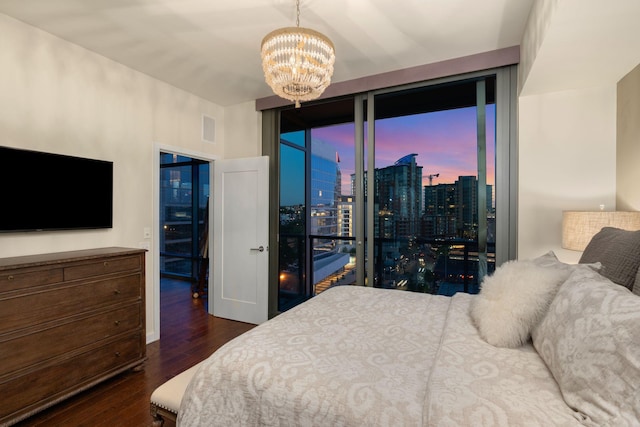 bedroom with dark wood-type flooring, access to outside, expansive windows, and a chandelier