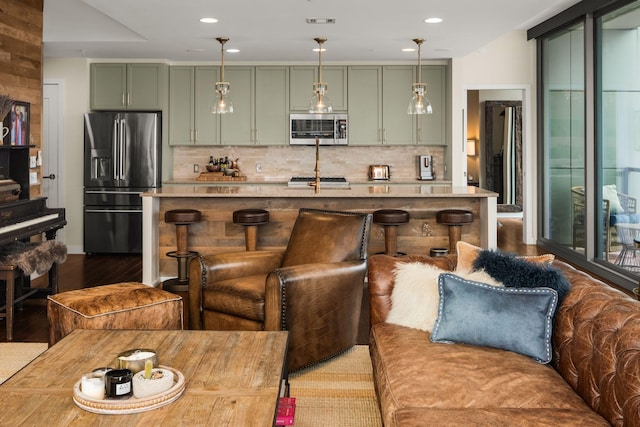 kitchen with tasteful backsplash, green cabinetry, high end black refrigerator, and decorative light fixtures