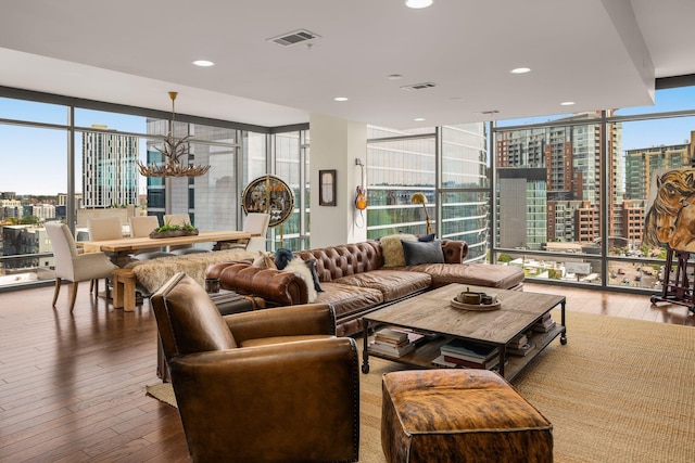 living room featuring hardwood / wood-style floors, an inviting chandelier, and a wall of windows