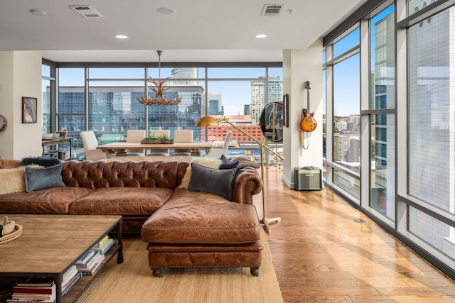 living room featuring expansive windows, an inviting chandelier, and light wood-type flooring