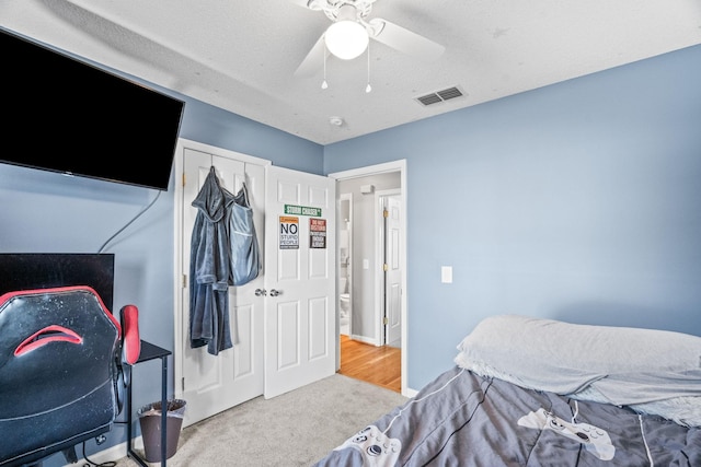 carpeted bedroom featuring a textured ceiling, ceiling fan, and a closet