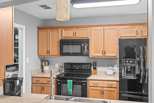 kitchen featuring sink, black appliances, and a textured ceiling