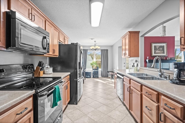 kitchen featuring light tile patterned flooring, pendant lighting, sink, a chandelier, and black appliances