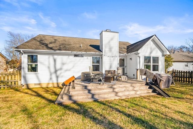 back of property with a wooden deck, a fire pit, and a lawn