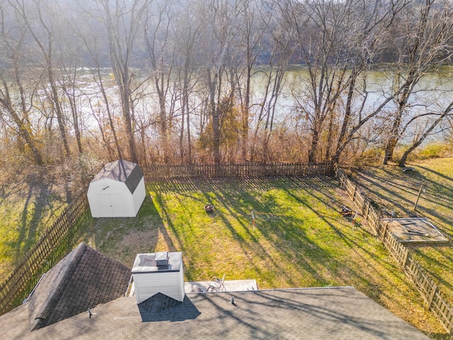 view of yard with a storage unit and a water view